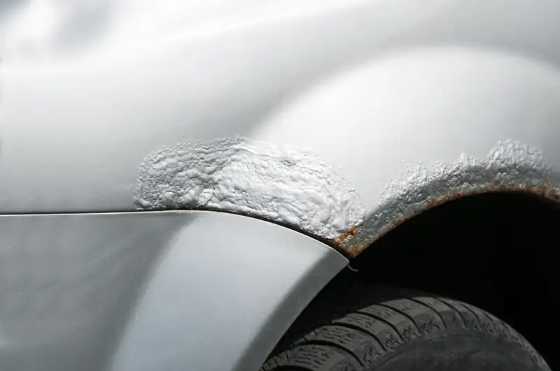 Rouille qui fait gonfler la peinture au-dessus de la roue d’une voiture
